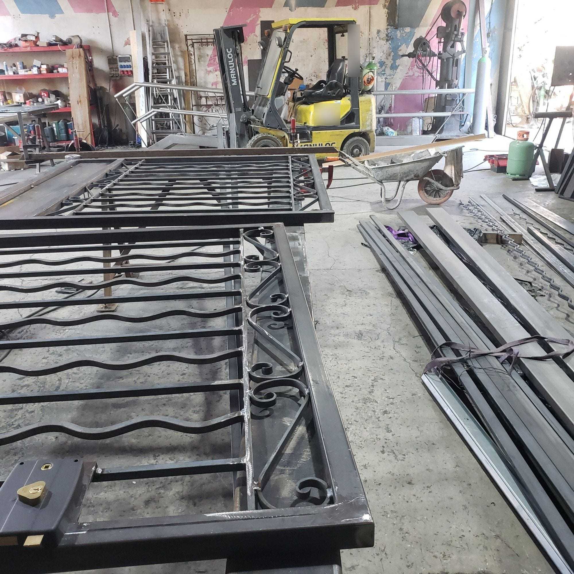 Deux portails en fer forgé à volutes en cours de fabrication dans l’atelier