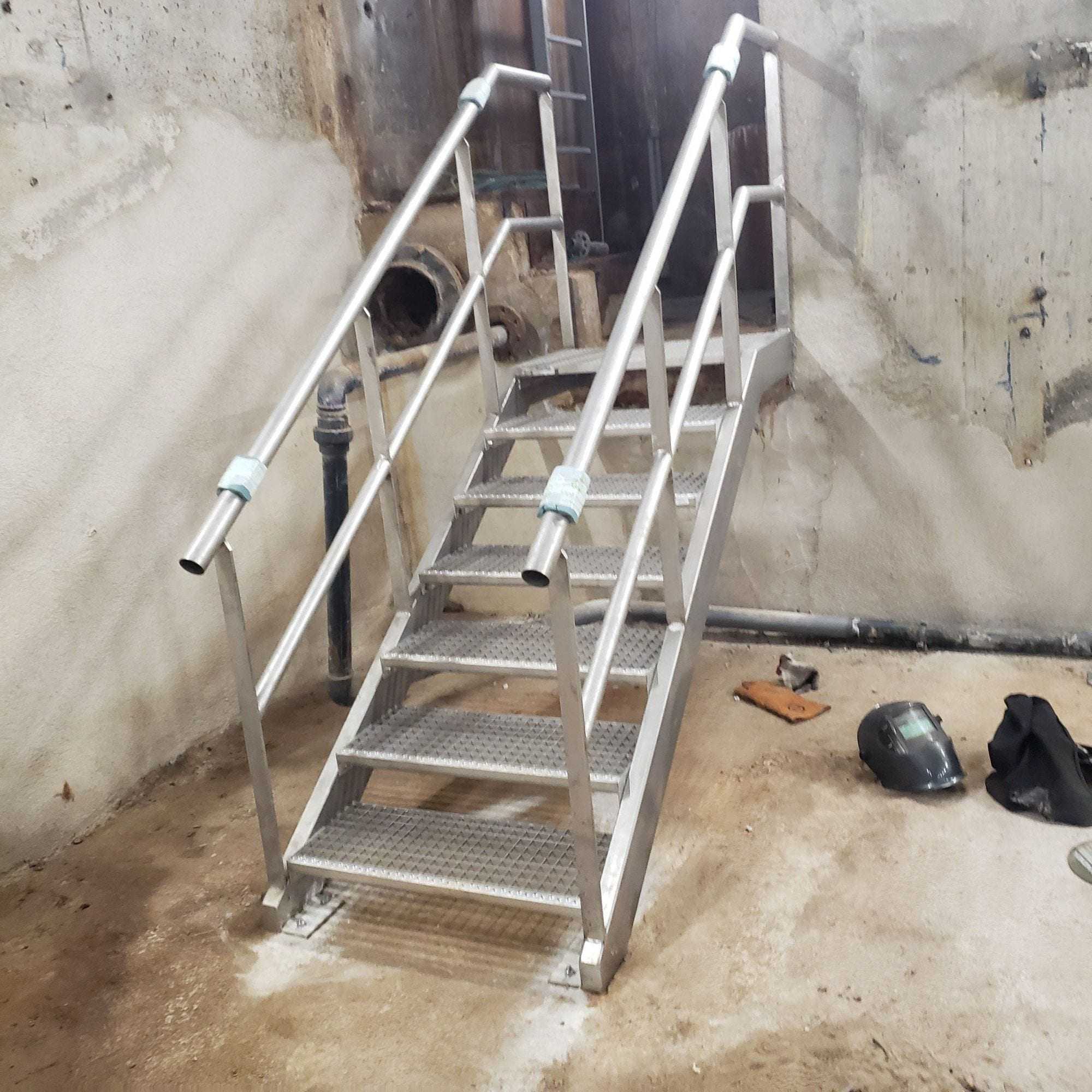 Escalier en inox à marches ajourées et mains courantes tubulaires