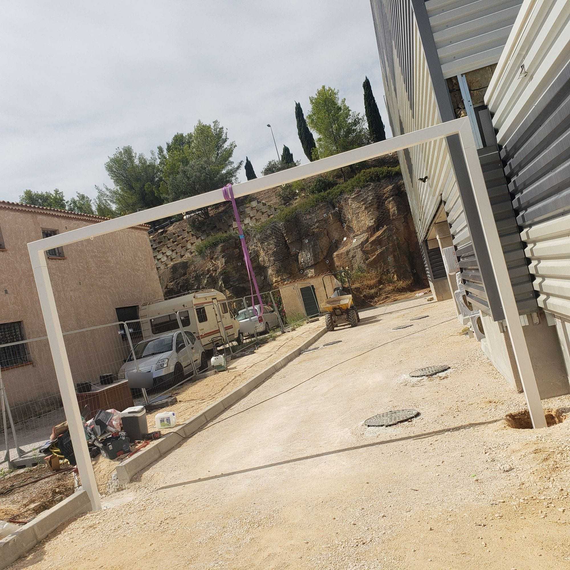 Portique blanc pour pergola posé sur un chantier