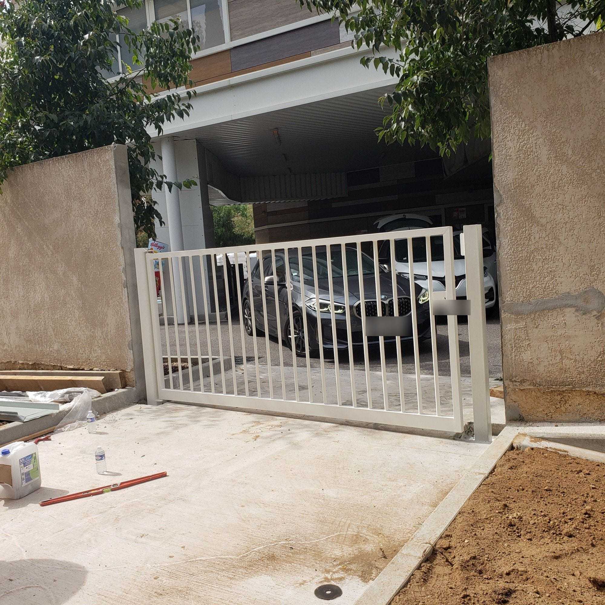Portail coulissant blanc installé, barreaudage vertical